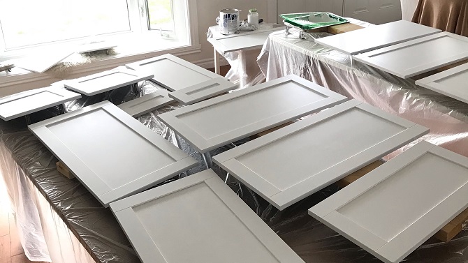 White cabinet doors laid out face up on tables